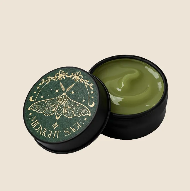 A tin of green comfrey salve with the midnight sage logo on the lid.