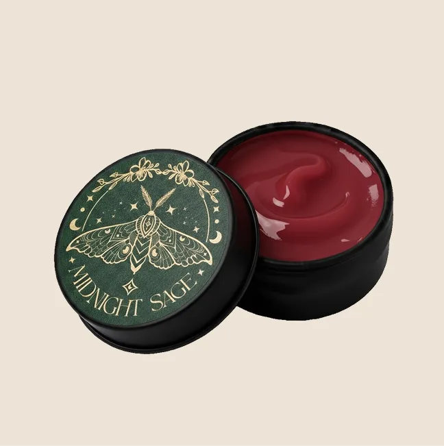 A tin of red St. John's wort salve with the midnight sage logo on the lid.